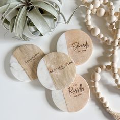 three personalized wooden coasters sitting next to a plant