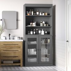 a bathroom with gray cabinets and white towels on the counter top, along with toiletries