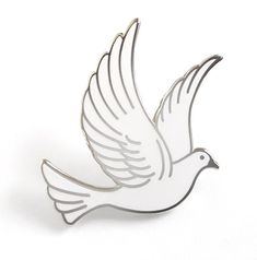 a white bird brooch sitting on top of a table