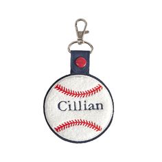 a baseball keychain with the name gill on it and a red ball in the center