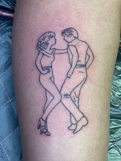 a man and woman dancing together on the thigh with tattoos on their legs that are drawn in black ink