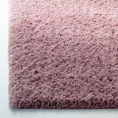 a pink area rug on a white floor