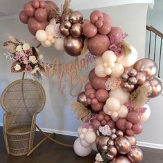 the balloon arch is decorated with pink, gold and white balloons