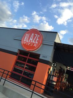 the entrance to blaze pizza on a sunny day with blue sky and clouds in the background