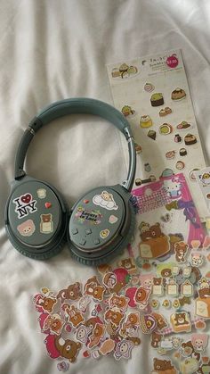 headphones and stickers are laying on a bed