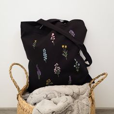 This elegant handpainted black canvas tote bag is a masterpiece designed for fashion-forward women seeking both style and functionality. Crafted with meticulous detailing, this tote showcases a stunning floral motif handpainted on a sleek black canvas background. The roomy interior offers ample space for your essentials, while the sturdy straps ensure comfortable carrying throughout the day. This versatile women's purse seamlessly transitions from work to play, making it a must-have accessory. M Cotton Hand-painted Bags For Daily Use, Embroidered Black Shoulder Bag As Gift, Artistic Black Canvas Bag As Gift, Artistic Black Canvas Bag Gift, Artistic Black Canvas Bag For Gift, Handmade Black Canvas Bags, Handmade Black Cotton Shoulder Bag, Black Embroidered Canvas Tote Bag, Black Embroidered Cotton Shoulder Bag