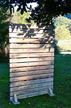 a wooden structure sitting on top of a lush green field