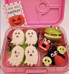 a pink lunch box filled with lots of different food items and some cute faces on them