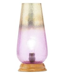 a purple glass vase sitting on top of a wooden base