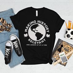 a t - shirt with the words making history relevant on it next to some shoes