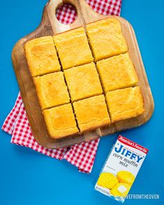 a wooden cutting board topped with squares of yellow cake