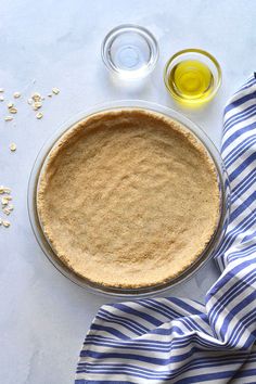 an uncooked pie sitting on top of a table next to a blue and white towel