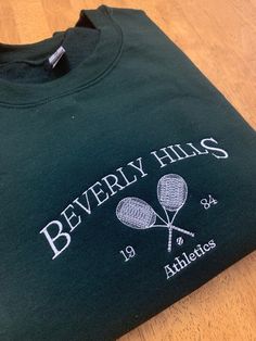 Beverly Hills Embroidered Sweatshirt  Available in other colors  ✰This item is MADE TO ORDER and can be shipped out within a week ✰Colors may vary due to color variations in monitors ✰All of the crewnecks are unisex and made of polyester and cotton material ✰These crewnecks are machine embroidered with 🫶 ✰Size up for oversized fit  ✰Please message me if you have questions about your order! ✰All sales are final Size Guide Length/Width Small- 27/20 in. Medium- 28/22 in. Large-29/24 in. XL-30/26 i College Crew Neck T-shirt With Embroidered Logo, Cotton Crew Neck Sweatshirt With Screen Print, Crew Neck Sweatshirt With Embroidered Logo, Sporty Embroidered Long Sleeve T-shirt, Crew Neck Top With Embroidered Logo For College, Casual Embroidered Sports Sweatshirt, Casual Embroidered Sweatshirt, Varsity Crew Neck Tops With Embroidered Graphics, Sports Season Embroidered Logo Crew Neck T-shirt