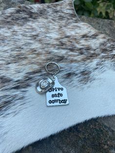 a keychain with the words positive, negative, and cowhide on it