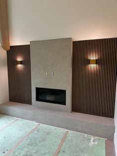 an empty room with a fire place in the center and wooden slats on the walls