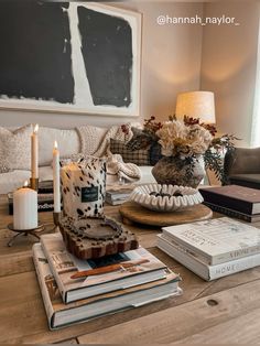 a living room filled with lots of furniture and books on top of a wooden table