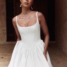 a woman in a white dress posing for the camera