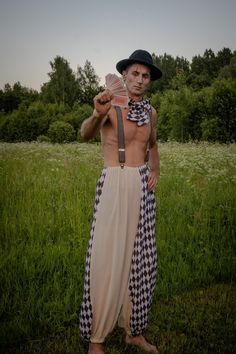 a man with no shirt on holding up a piece of paper in front of his face