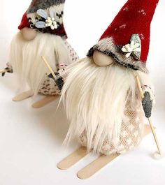 two small gnomes with long white hair and red hats