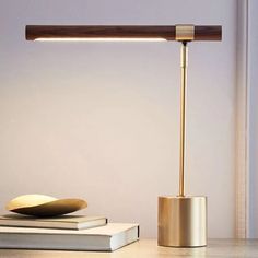 a desk lamp sitting on top of a table next to books