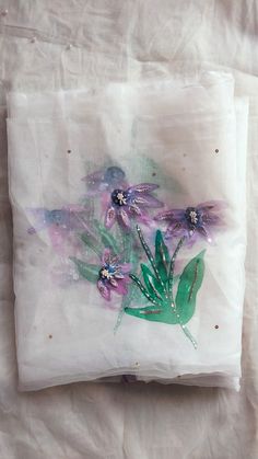 some purple and green flowers on a white sheet