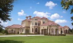 a large house in the middle of a lush green field