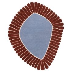 an oval shaped rug with blue and brown accents on the bottom, in front of a white background