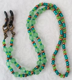 You'll always keep your reading glasses nearby using this green & brown beaded eyeglass chain! 25" in length, made with glass beads, beading cord, metal lobster clasps, and adjustable rubber holders. Lobster clasps make it easy to change the rubber holders, and an extra pair of holders included with every purchase. This green & brown beaded eyeglass chain will arrive in a gift box, ready to give as a present or to keep and store. Back to Beaded Eyeglass Chains Adjustable Green Double Strand Beaded Necklace, Adjustable Green Necklace For Everyday Use, Everyday Adjustable Green Necklace, Adjustable Czech Glass Beaded Necklaces With Lobster Clasp, Adjustable Green Czech Glass Beaded Necklaces, Adjustable Round Beaded Necklaces For Everyday, Adjustable Colorful Beaded Jewelry For Everyday Use, Adjustable Beaded Chain Necklace For Everyday, Adjustable Round Bead Glass Necklaces