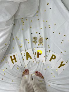 a person's feet are shown with gold confetti and happy birthday cards