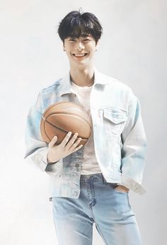 a young man holding a basketball in his right hand and smiling at the camera while standing against a white background