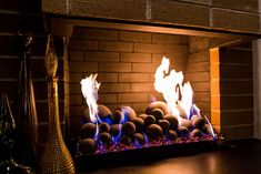 a fireplace with fire burning in it and blue flames coming out of the top one