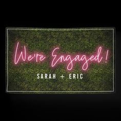 we're engaged neon sign with the words, sarah + eric on it