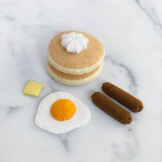 an egg, sausage and pancakes on a marble surface