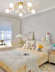 a bed room with a neatly made bed next to a window and a lamp hanging from the ceiling