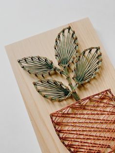 three decorative items made out of bamboo on top of a wooden cutting board with string