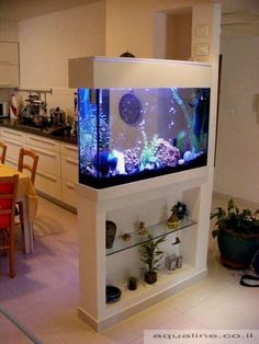 a fish tank sitting on top of a white shelf next to a dining room table