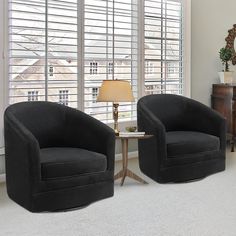 two black chairs sitting next to each other in a living room