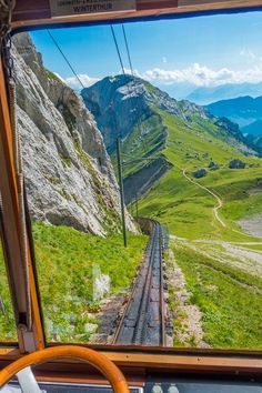 the view from inside a train looking down at mountains