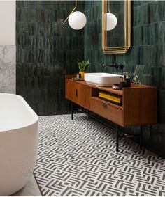 a bathroom with a sink, mirror and bathtub next to a large white tub