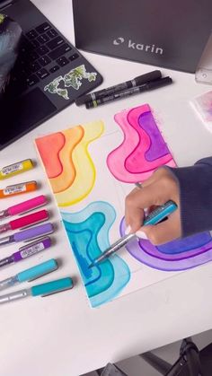 a person is drawing on paper with markers