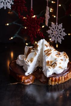 a piece of pie with whipped cream and chocolate on top, sitting on a table