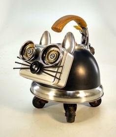 a silver and black cat tea kettle on wheels