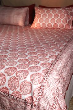 a bed with red and white bedspread on top of it