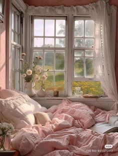 a bed with pink sheets and pillows in front of a window filled with white flowers