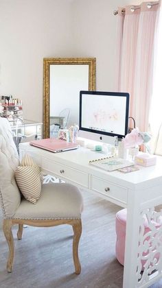 a white desk topped with a computer monitor sitting next to a chair and table covered in items