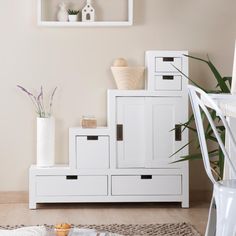 a living room with white furniture and plants