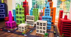 colorful toy city blocks on the floor in front of a window