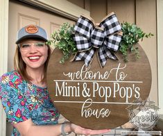 a woman holding up a sign that says welcome to mimi and pop's house