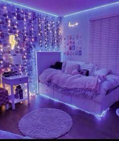 a bedroom decorated in purple and white with lots of lights