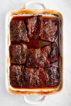 meatloaf in a white casserole dish on a marble countertop, ready to be eaten